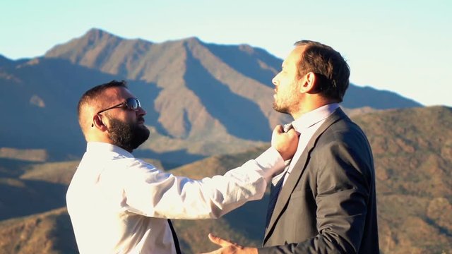 Two businessmen fighting in the mountains, super slow motion
