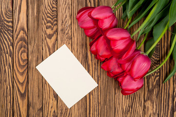 Tulips on a wooden background. Space for text. Top view