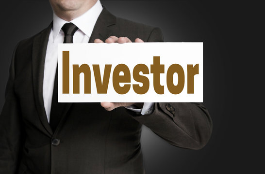 investor placard is held by businessman background