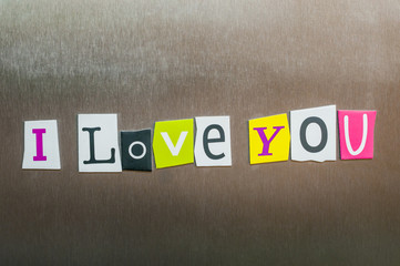 I Love You written with color magazine letter clippings on metal background. Design for relationships, romance, love and Valentines day