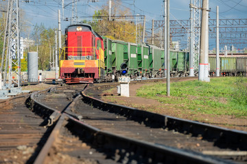 Red locomotive and Green freight cars on the rails