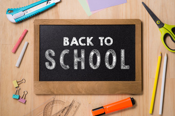 Desk with stationary and with Back to school sign. Studio shot on wooden background.