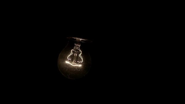 Glowing hanging light bulb dangle on a wire