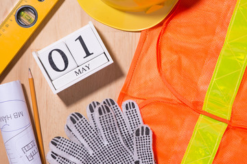 May 1st. Image of may 1 white blocks wooden calendar with construction tools on the table. International Workers' Day. Labor day concept.