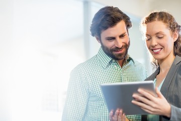  Businessman and businesswoman discuss using digital tablet