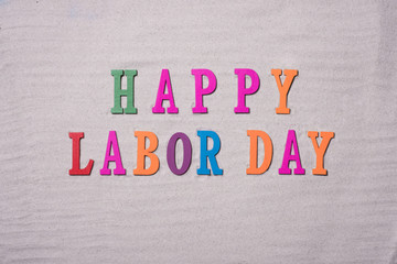 Happy Labor Day on the sandy beach background. Happy Labor Day word in colorful stones