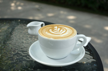 Cups of latte art coffee on black table