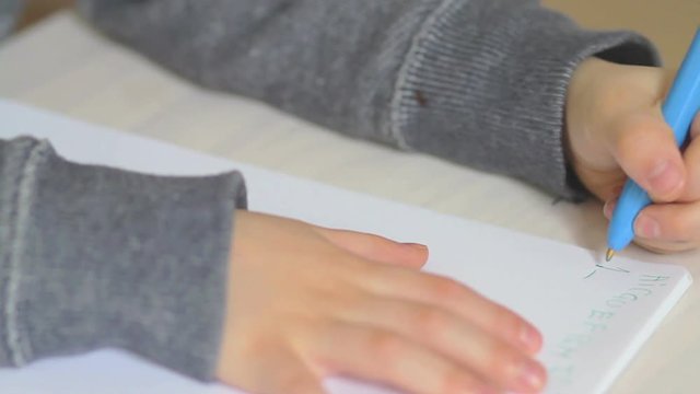 Boy writing numbers on exercise book. Numbers 1 to 5