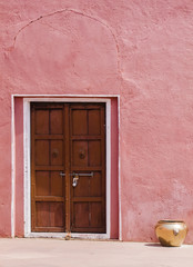 wooden door in a pink wall