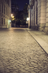 Obraz premium empty brick road at night with blurred background, vintage filtered style, historic midtown of Berlin, Germany, Europe 