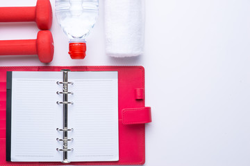 Workout plan and sports equipment top view close-up