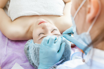 Beautiful woman in spa salon receiving epilation or correction e