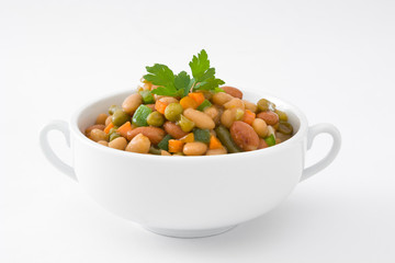 White beans with vegetables in a bowl isolated on white background