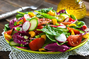 Fresh vegetable salad on wooden background