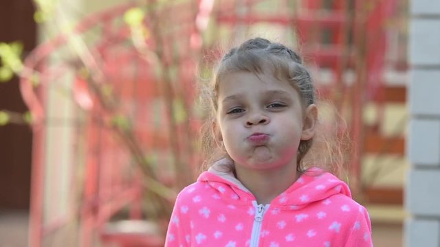 Girl five years old funny inflates cheeks