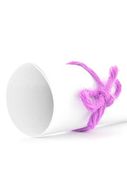 Handmade pink string node tied on white paper package isolated