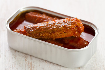 fish in tomato sauce in iron box on white background