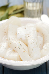 strips of octopus on white dish on brown wooden background