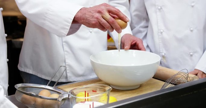Chef cracking an egg into a bowl