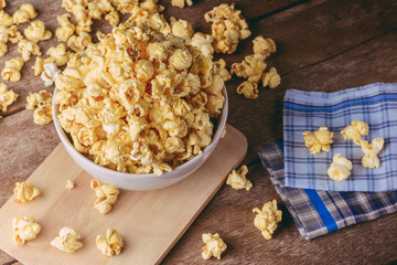 bowl of popcorn on the wooden table, selective focus