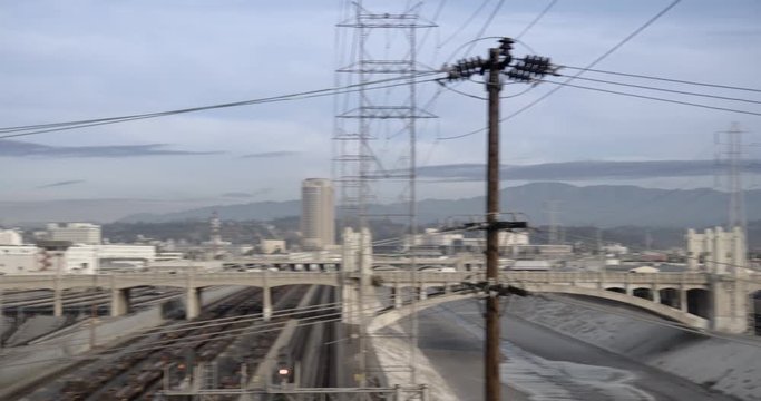 LOS ANGELES, CA, USA  - DECEMBER 2015:  Pan across the Los Angeles River to Downtown skyline, viewed across the Arts District, morning. Originally recorded in 4K DCI.