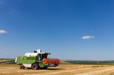 Obraz premium Combine harvester working on a wheat field.
