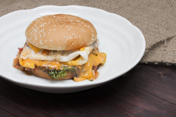 hamburger in plate on wood table.