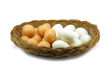 Duck eggs and brown eggs in the basket isolated on white backgro