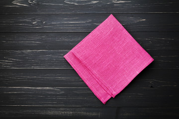 Linen kitchen towel or napkin on black wooden background, top view