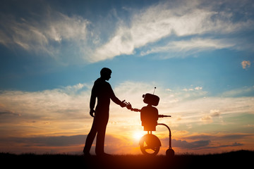 Man and robot meet and handshake. Concept of the future interaction with artificial intelligence - obrazy, fototapety, plakaty
