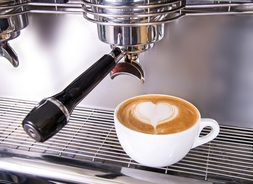 Cappuccino in einer Tasse mit Milchschaum und Herzmuster