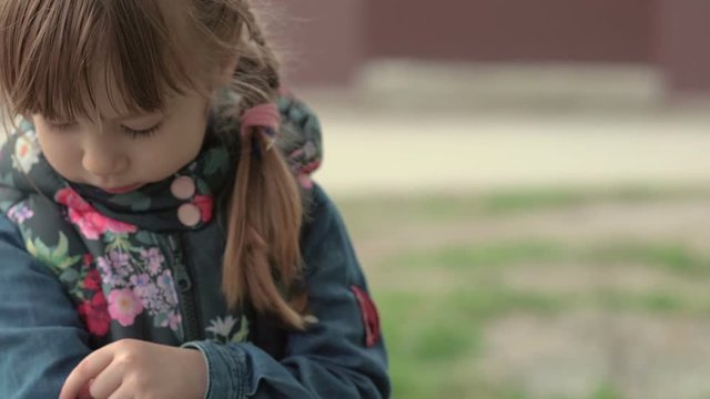 Little girl looks at the petal.