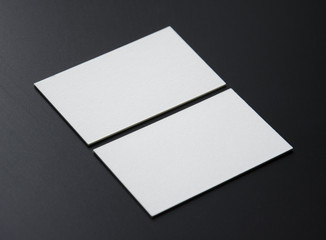 Blank white business cards on a black background. Photo mock-up.