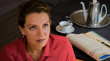 Portrait einer nachdenklichen attraktiven Frau beim Tee