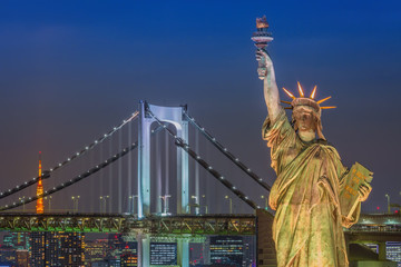 Obraz premium Statue of Liberty and Rainbow bridge, located at Odaiba Tokyo, w