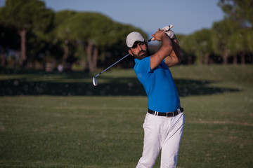 pro golfer hitting a sand bunker shot