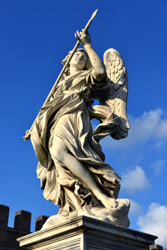 Angel with the Holy Lance of Longinus looks at the sky. Marble statue from Sant'Angelo bridge monumental balustrade in the center of Rome