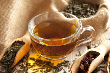 Cup of tea and tea leaves on wooden table