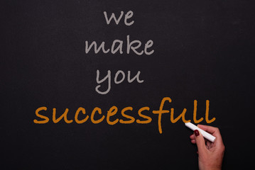 Fototapeta premium Woman writes on blackoard - we make you successfull