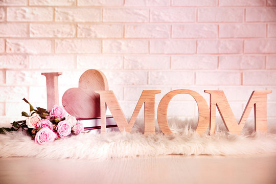 I love mom inscription made of wooden letters with heart on brick wall background