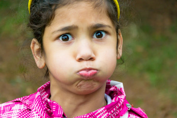 Little gypsy girl child holding breath funny portrait
