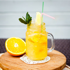 Preparation of the lemonade drink with tubes. Lemonade in the jug with lemons with mint on the table