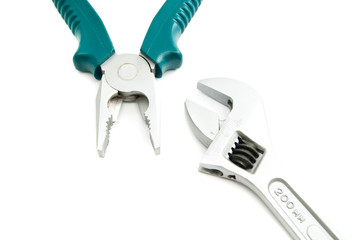 adjustable wrench and pliers on white