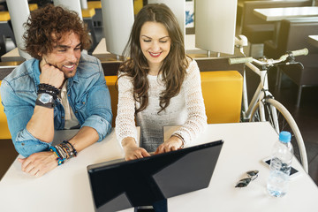 Couple using the laptop in the restaurant.
