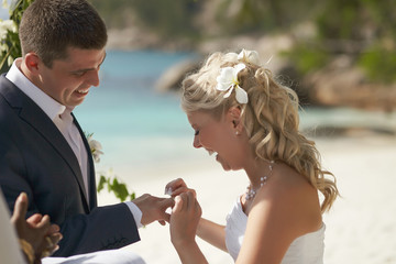 Couple exchanging rings during wedding registry ceremony on trop