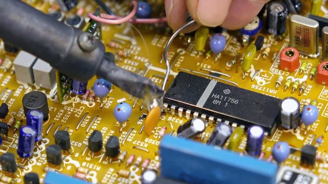 Engineer soldering circuit board. Close-up shot
