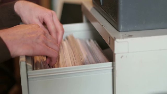 The man pulls out a file