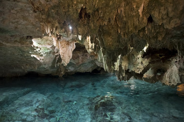 Inside of stone cave with blue water and rocks - 109088583