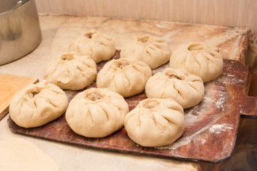Vak belesh - bashkir national cuisine, homemade meat pies over wooden board frosted with flour