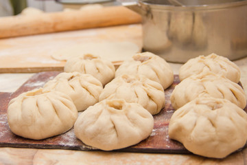 Vak belyash - bashkir national homemade meat pies on wood chopping board at home kitchen